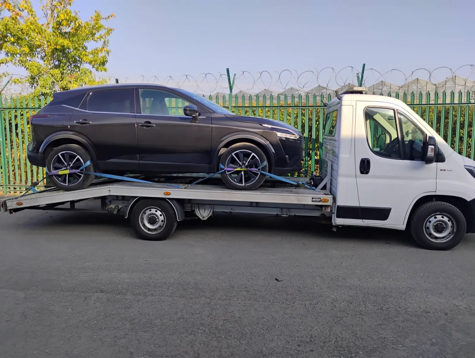 Black Nissan Qashqai secured on the flatbed for delivery