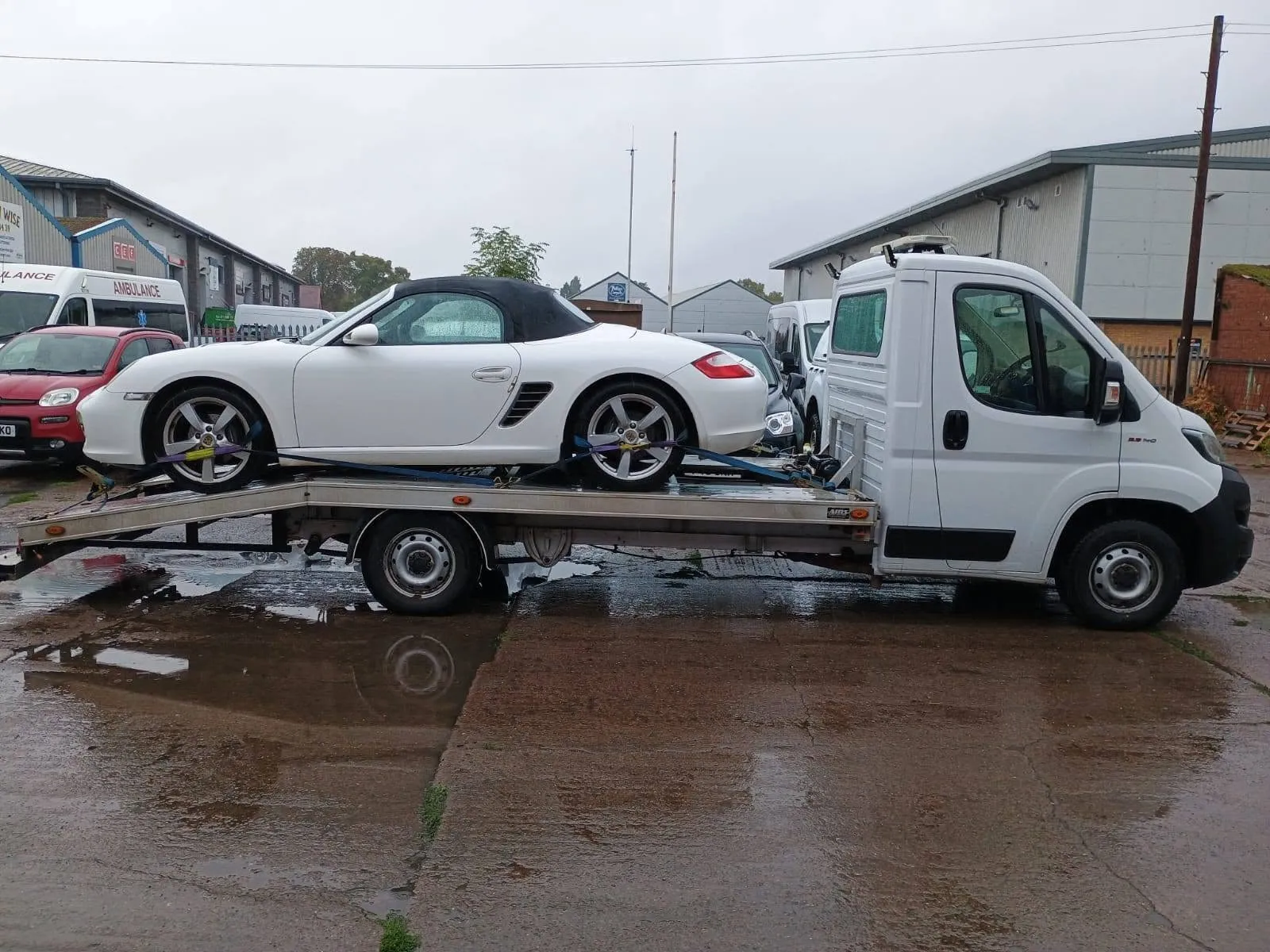 White Porsche Boxster strapped onto the transporter